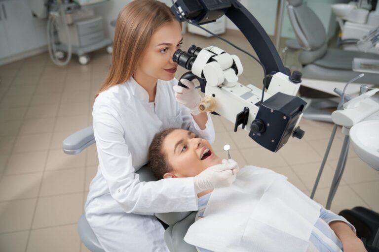 dentist looking through dental microscope on teeth
